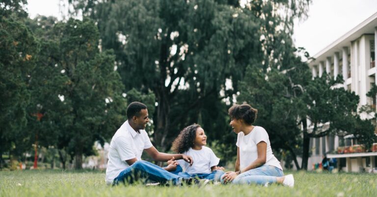 Family Sitting on Grass Near Building