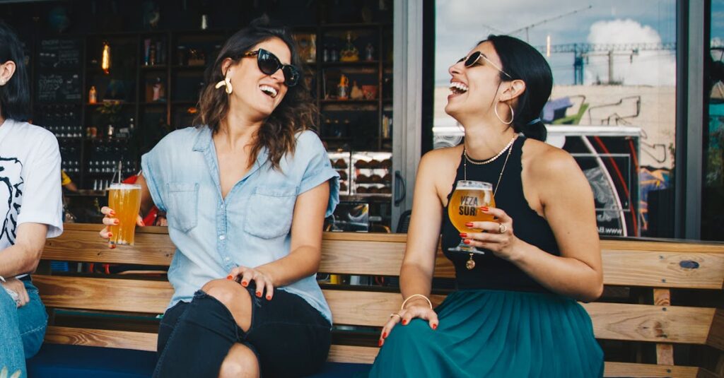 Two Smiling Women Sitting on Wooden Bench