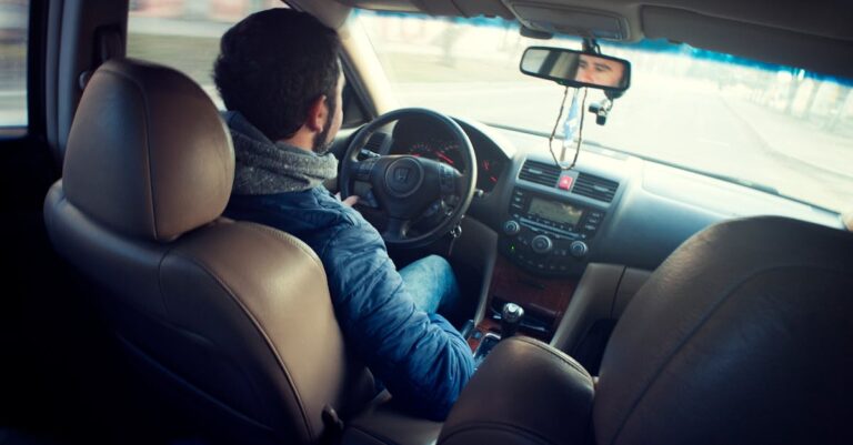 Man Wearing Blue Jacket Sitting Inside Car While Driving