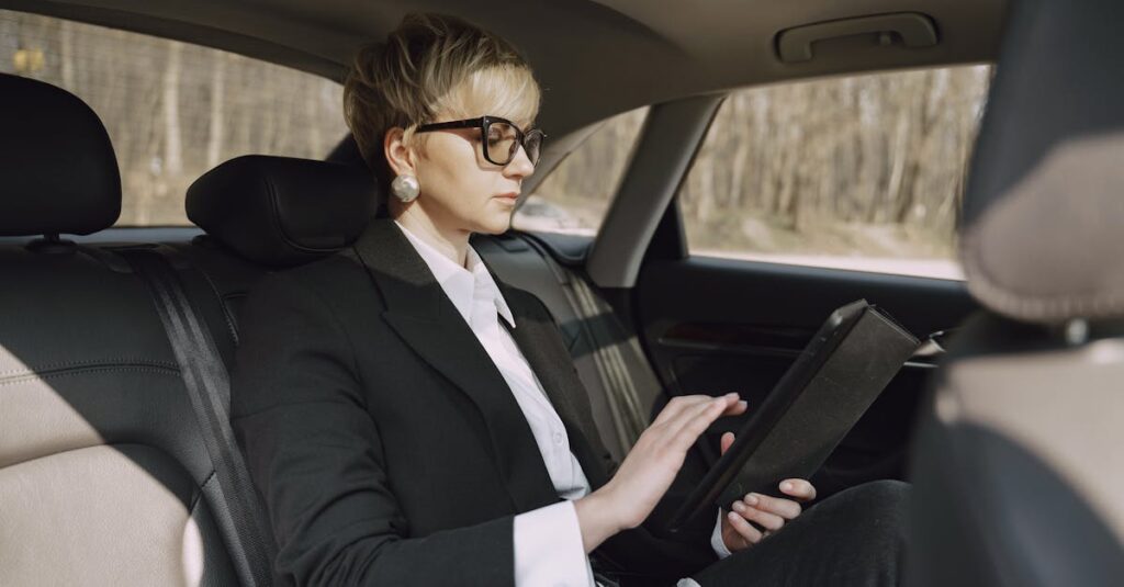 Serious woman using tablet in car