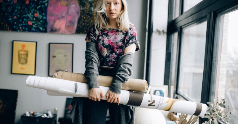 Woman in Black and Pink Floral Long Sleeve Shirt and Black Denim Jeans Standing Beside White