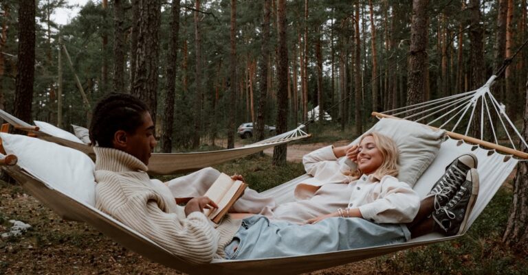 Photograph of a Woman Lying Beside a Man Reading a Book