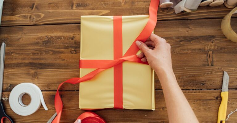 Person Holding Yellow and Red Paper Bag