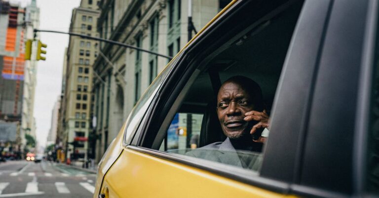 Man Sitting By The Window Of A Yellow Car