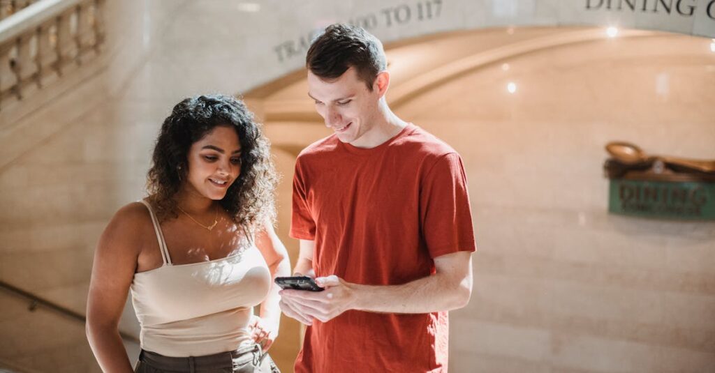 Positive young multiethnic couple browsing smartphone during trip in New York