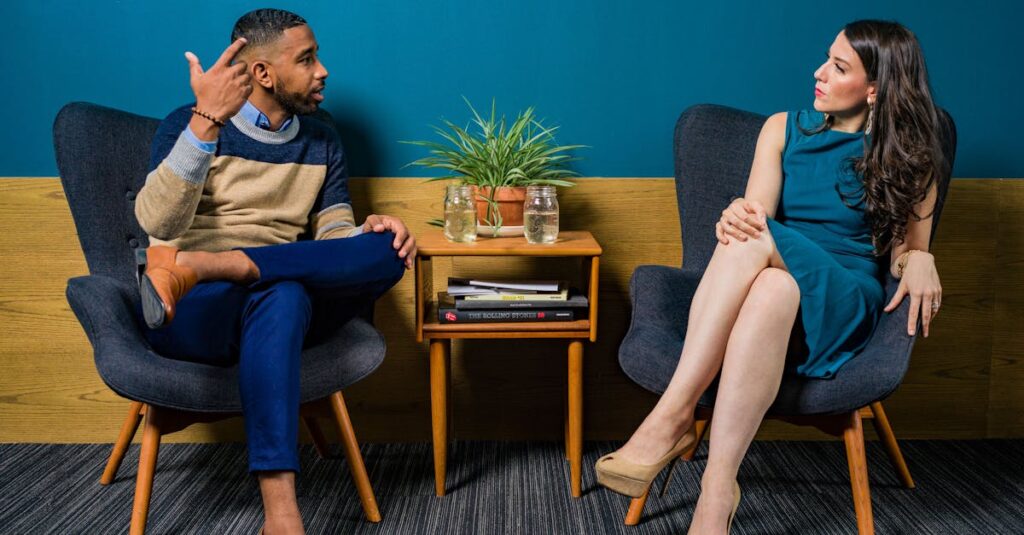 Woman Wearing Teal Dress Sitting on Chair Talking to Man