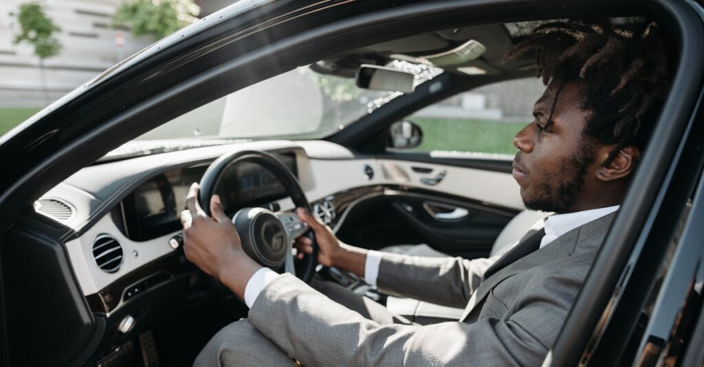 Confident businessman with dreadlocks driving a luxury car in formal attire.