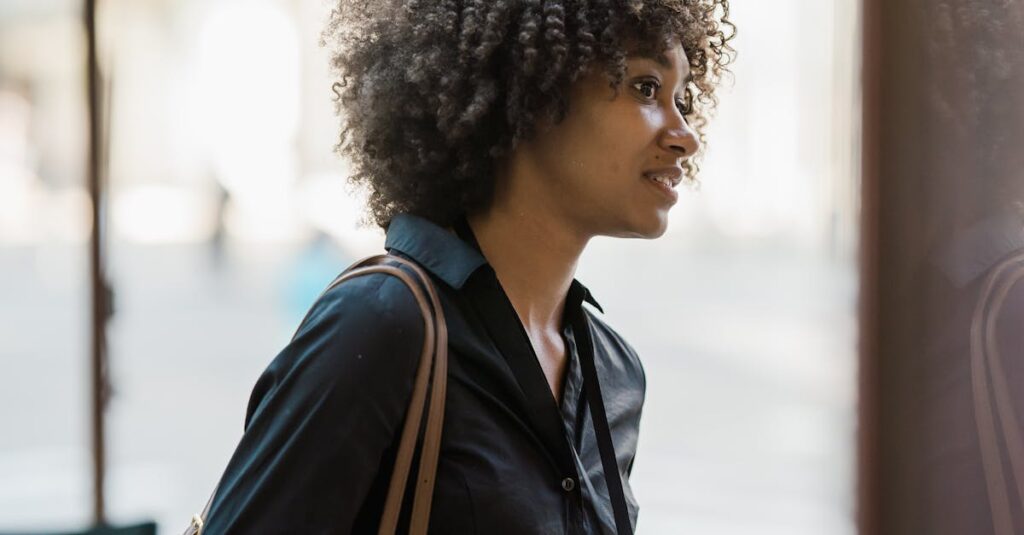 An adult woman with a fashionable afro hairstyle standing in an urban street setting, exuding confidence.