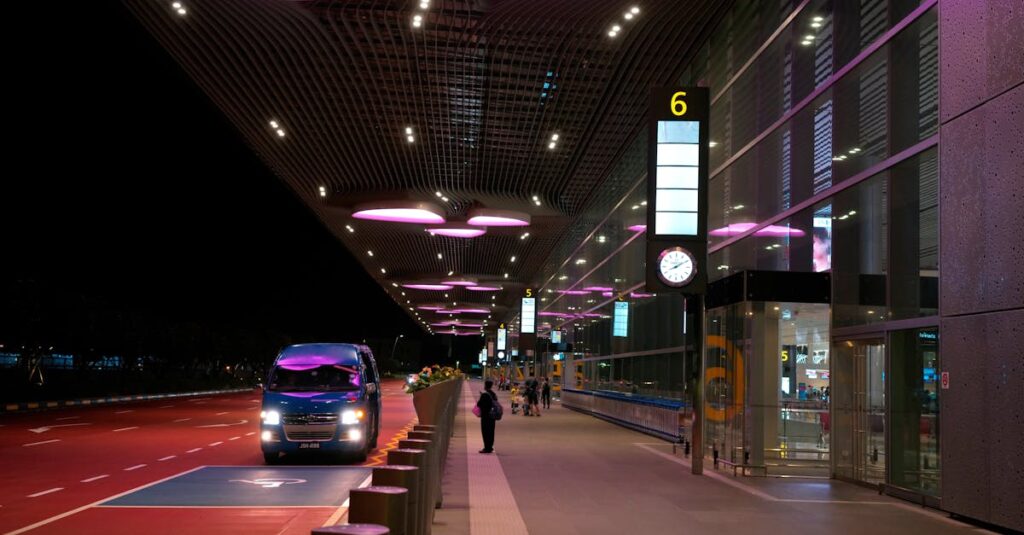 Night view of Singapore's Changi Airport entrance with illuminated canopy and bus.