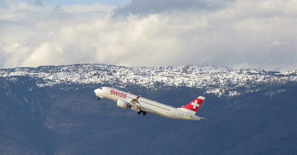 A Swiss airplane taking off with snow-capped mountains in the background in Geneva, Switzerland.