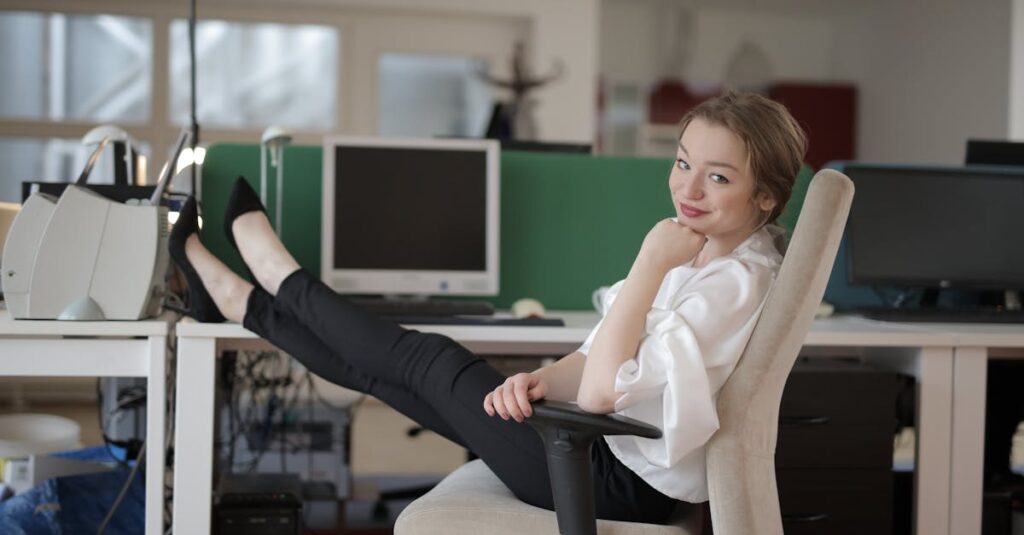 Woman in business attire relaxing with feet up in a modern office setting.