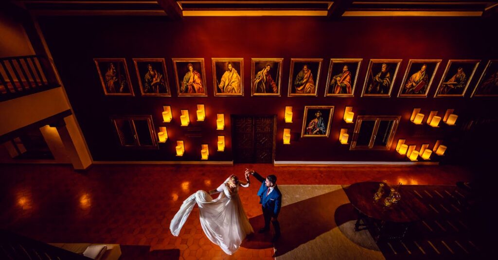 Couple dancing indoors, surrounded by art, showcasing elegance and romance in Toledo, Spain.