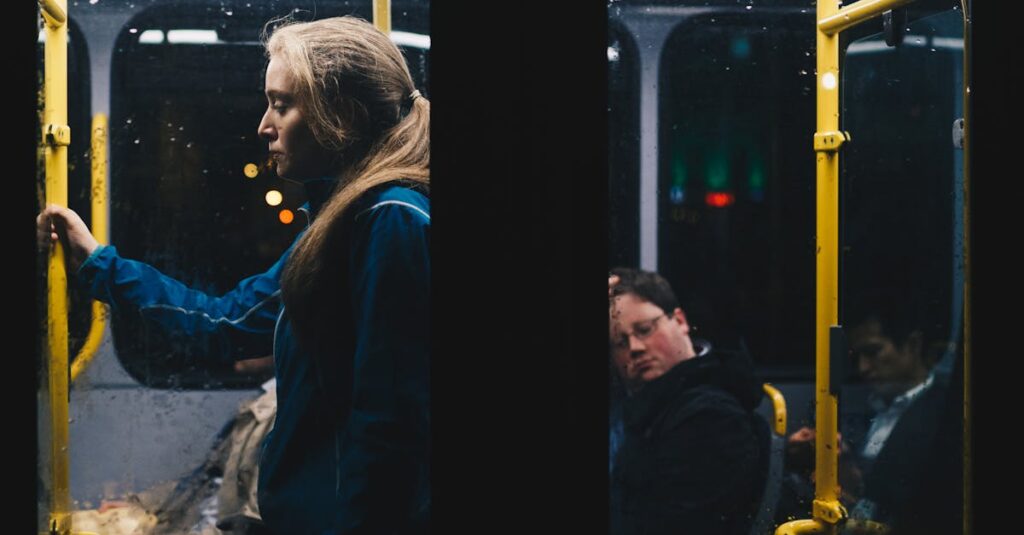 A solitary woman stands in a dimly lit Dublin city bus during a nightly commute.