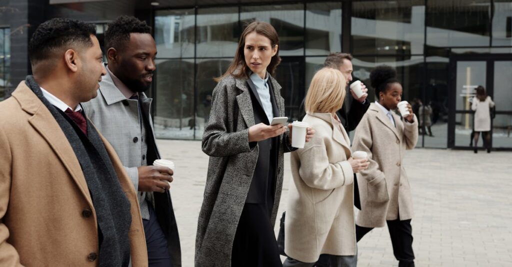 A group of diverse business professionals enjoying a coffee break outdoors in the city.