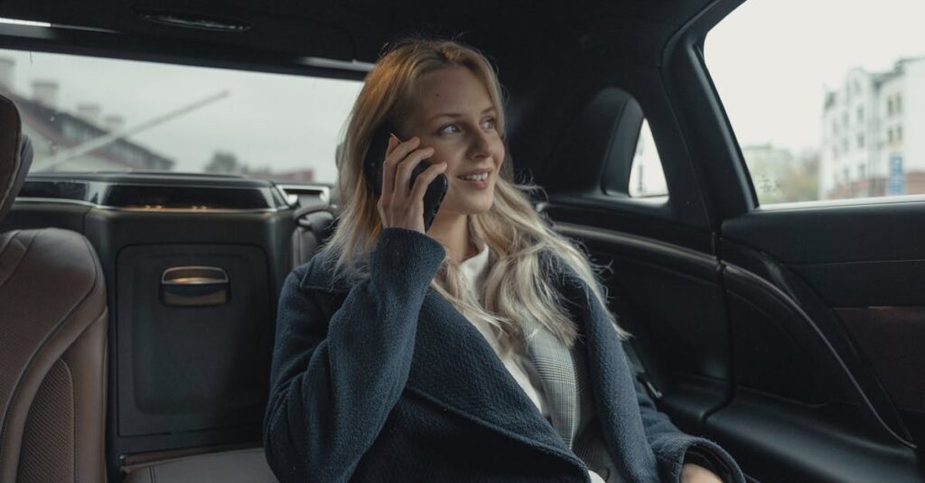 Businesswoman talking on phone while sitting in a luxury car, portraying professionalism and leadership.