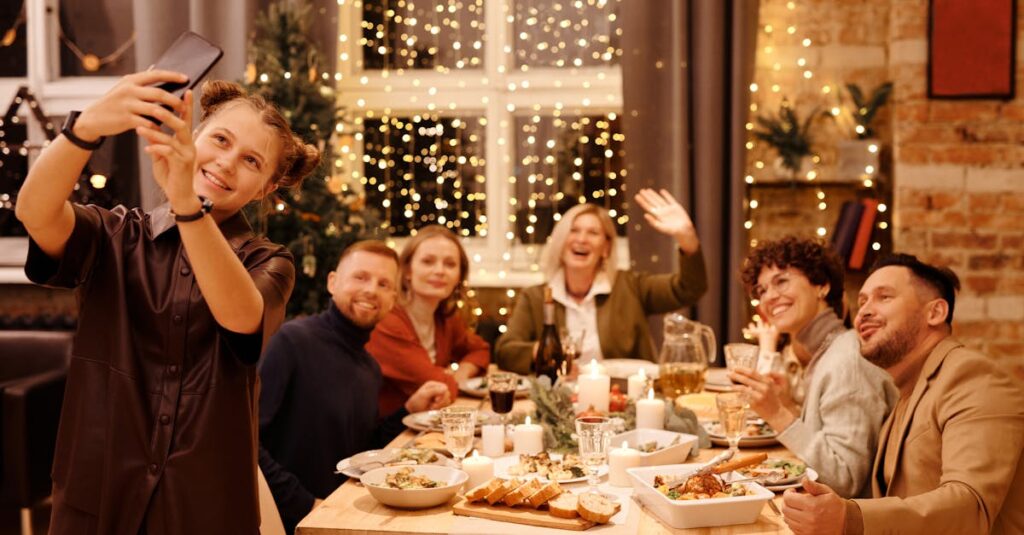 A joyful family capturing a selfie during a festive Christmas dinner indoors.