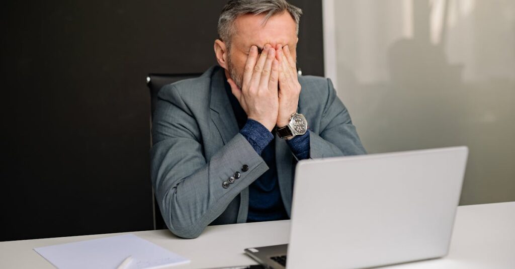 Businessman in gray suit showing frustration while working in office.