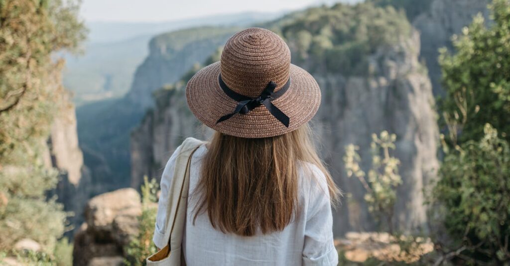 A woman in a hat enjoys the breathtaking view of a canyon, capturing the essence of adventure and travel.